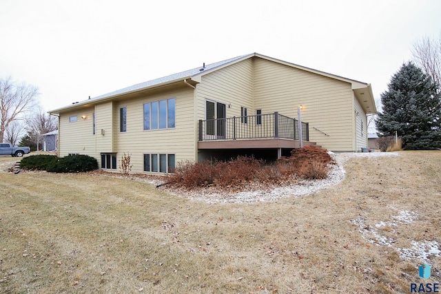 rear view of property with a yard and a wooden deck