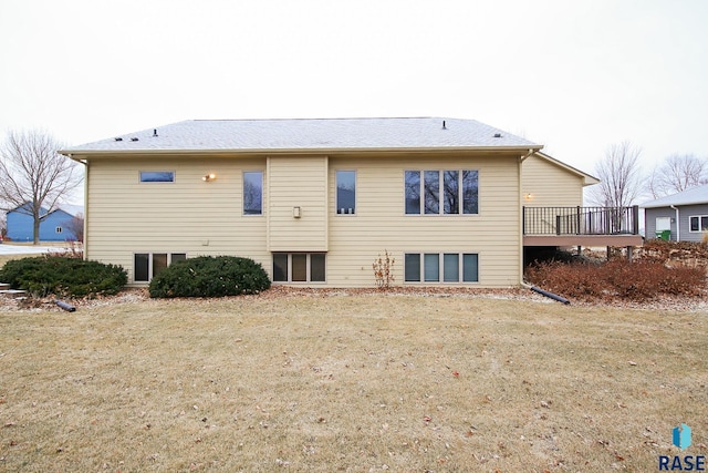 rear view of property with a yard and a deck