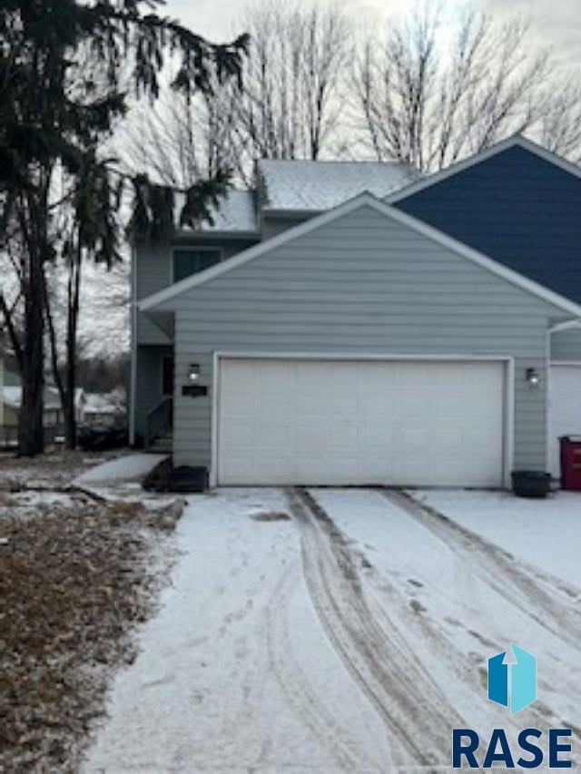 view of snowy exterior featuring a garage