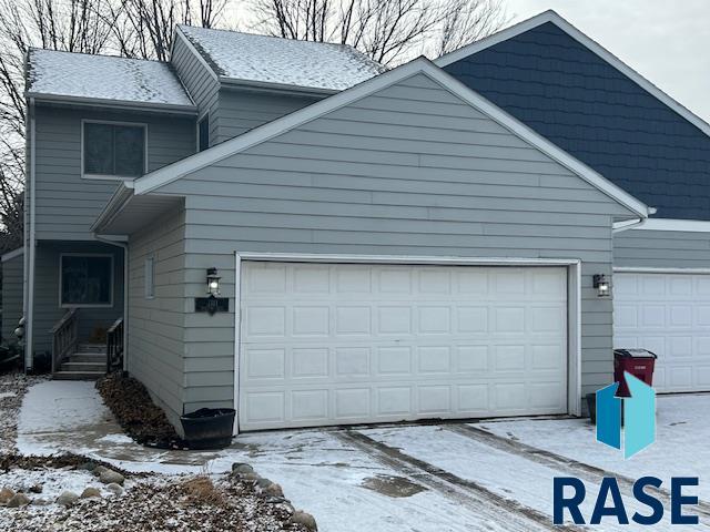 view of snow covered exterior with a garage