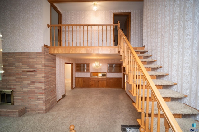 stairway featuring carpet floors and a brick fireplace