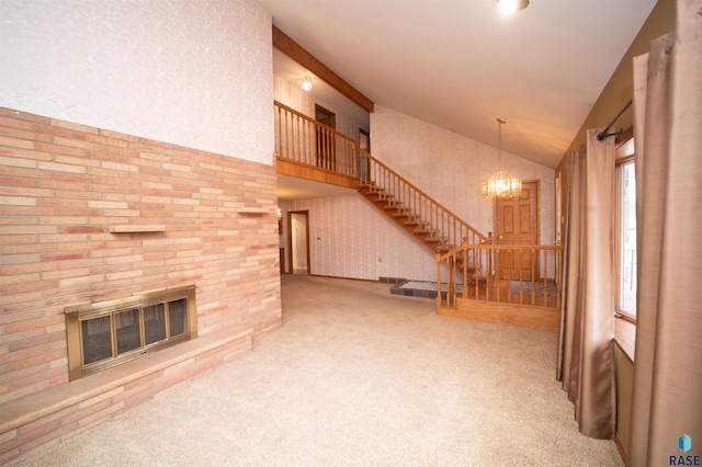 unfurnished living room with a notable chandelier, lofted ceiling, carpet floors, and a brick fireplace