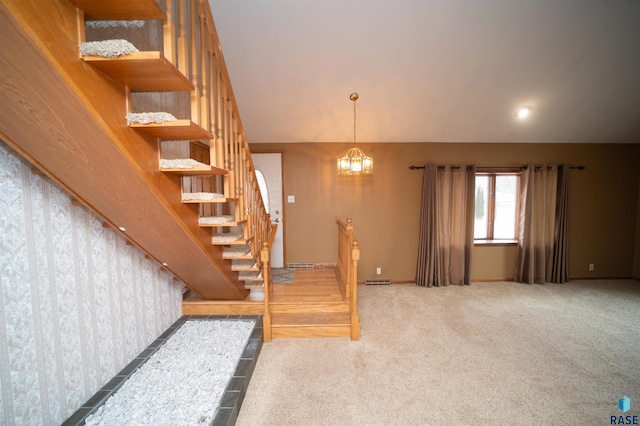 stairway with carpet and a notable chandelier