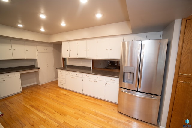 kitchen featuring white cabinets, stainless steel fridge, and light hardwood / wood-style flooring