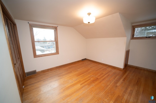 bonus room featuring lofted ceiling and light wood-type flooring