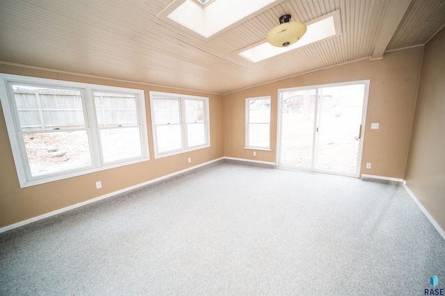 carpeted spare room with lofted ceiling with skylight and wooden ceiling