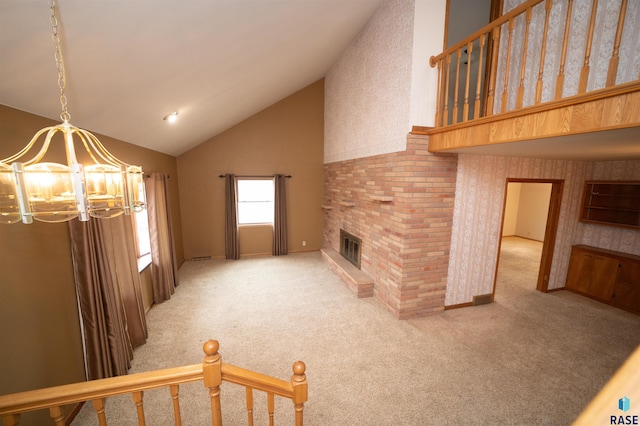 living room with carpet flooring, a chandelier, lofted ceiling, and a brick fireplace