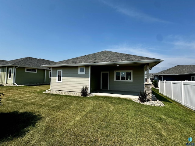 back of house with a lawn and a patio