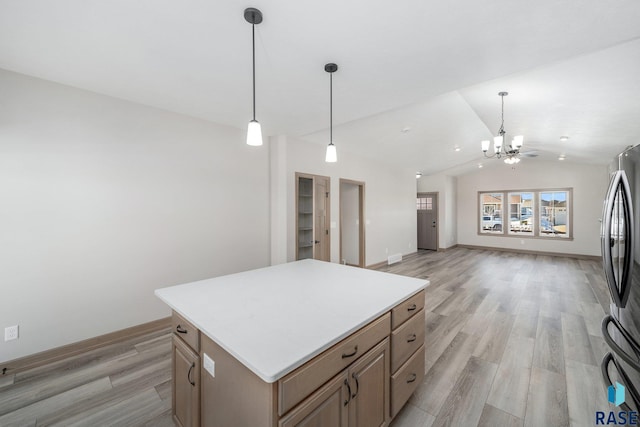 kitchen featuring a center island, hanging light fixtures, vaulted ceiling, stainless steel fridge, and light wood-type flooring