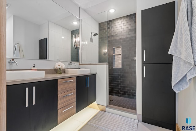 bathroom with double vanity, a stall shower, tile patterned flooring, and a sink