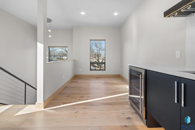 interior space with recessed lighting, beverage cooler, light wood-style flooring, and baseboards