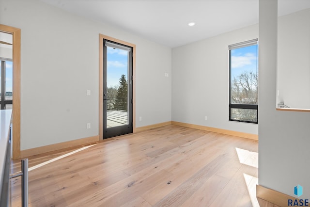 unfurnished room with recessed lighting, light wood-style flooring, and baseboards