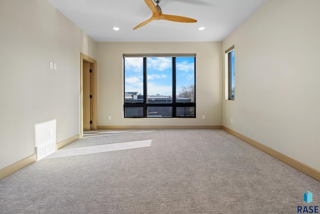 spare room with recessed lighting, light carpet, ceiling fan, and baseboards