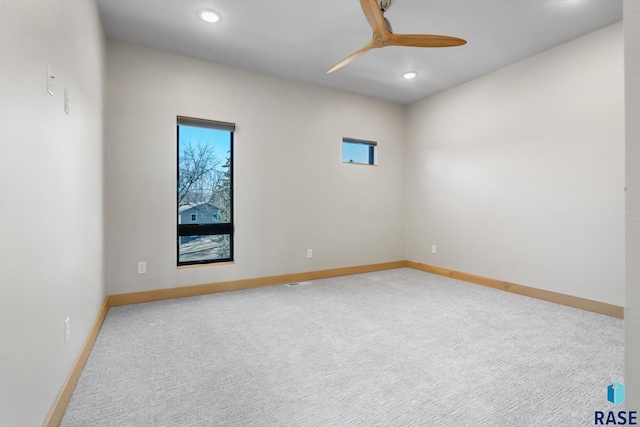 carpeted spare room featuring a ceiling fan, a wealth of natural light, baseboards, and recessed lighting