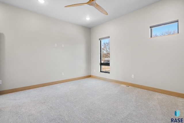 empty room featuring ceiling fan, recessed lighting, light colored carpet, visible vents, and baseboards