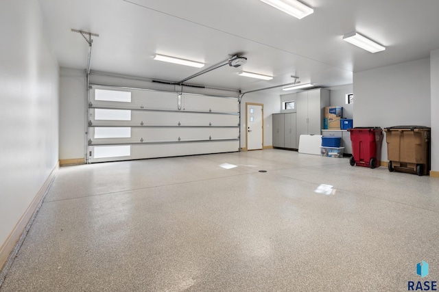 garage with baseboards and a garage door opener