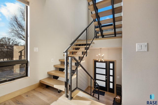 stairway with a chandelier and wood finished floors