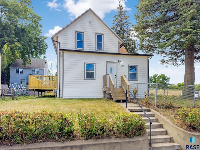 view of front of home with a wooden deck and a front yard