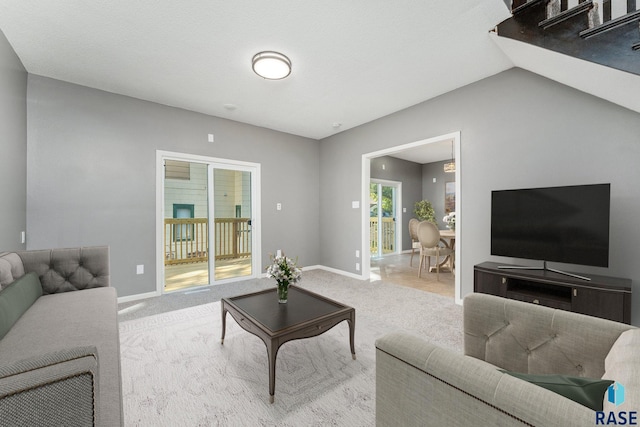 carpeted living room with lofted ceiling