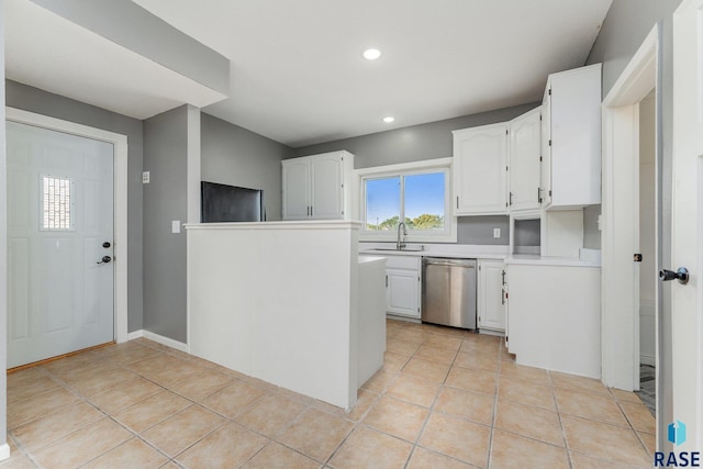 kitchen with white cabinets, light tile patterned flooring, stainless steel dishwasher, and sink