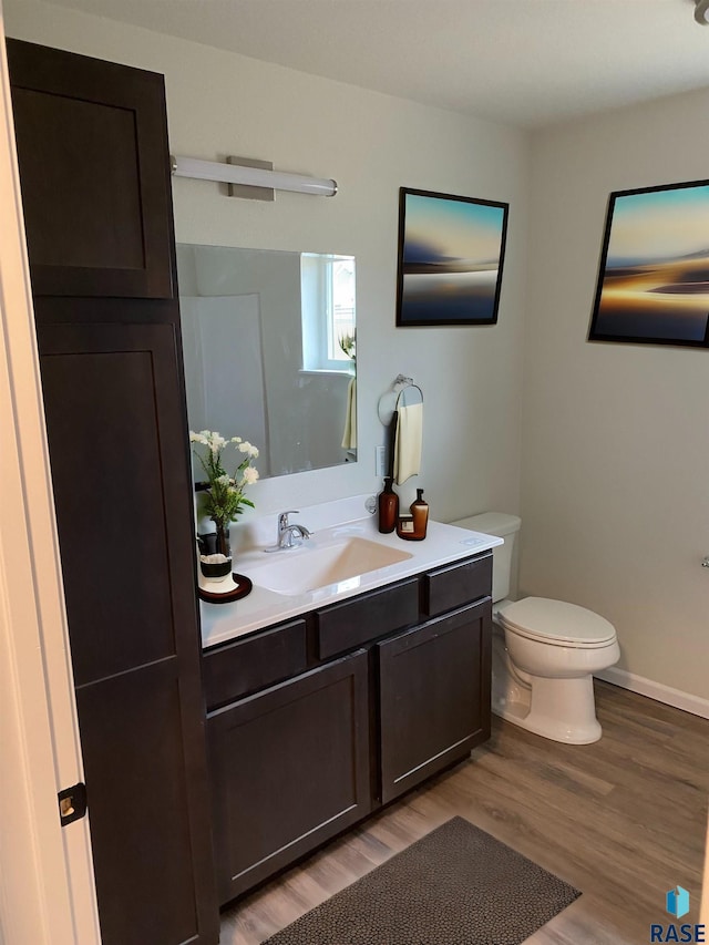 bathroom featuring hardwood / wood-style floors, vanity, and toilet