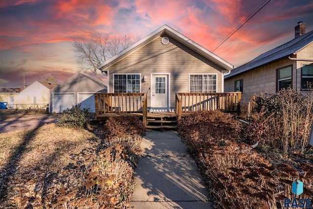 view of front of property featuring an outbuilding, a garage, and a deck