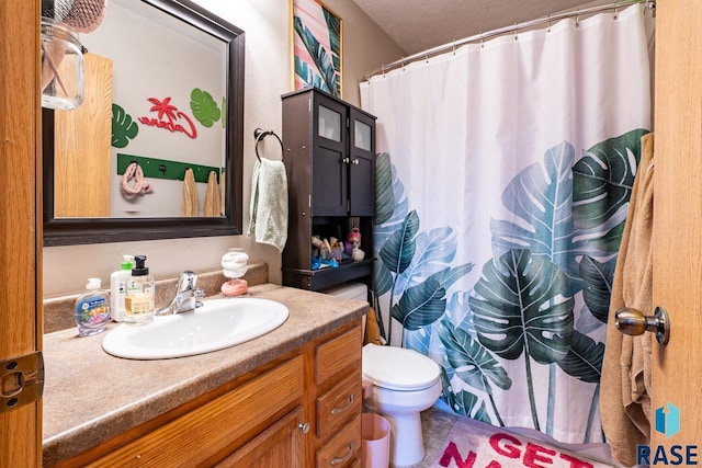 bathroom featuring vanity, toilet, and a textured ceiling