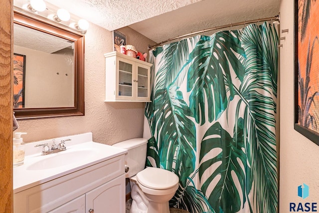 bathroom with vanity, a textured ceiling, and toilet