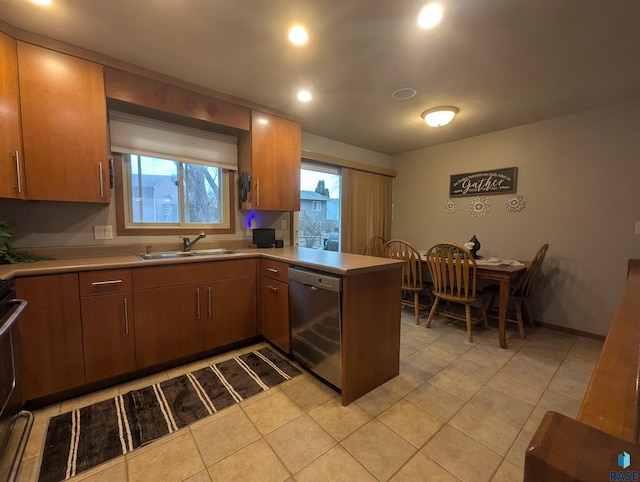 kitchen featuring stainless steel dishwasher, kitchen peninsula, sink, and a wealth of natural light