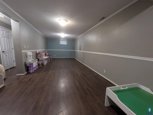 rec room with dark hardwood / wood-style flooring, a textured ceiling, and ornamental molding