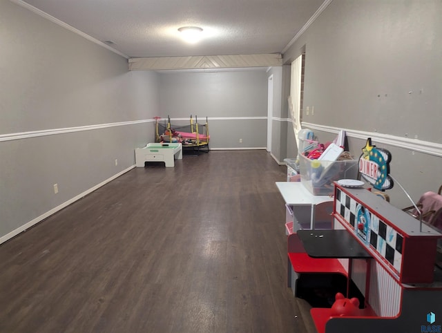 game room with a textured ceiling, dark hardwood / wood-style floors, and crown molding