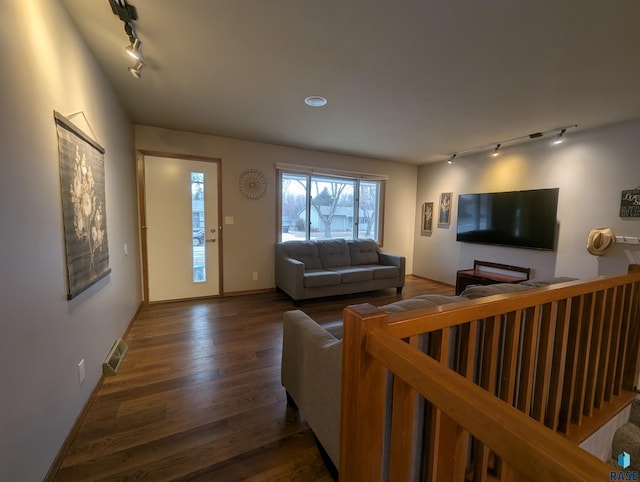 living room with dark hardwood / wood-style flooring and track lighting