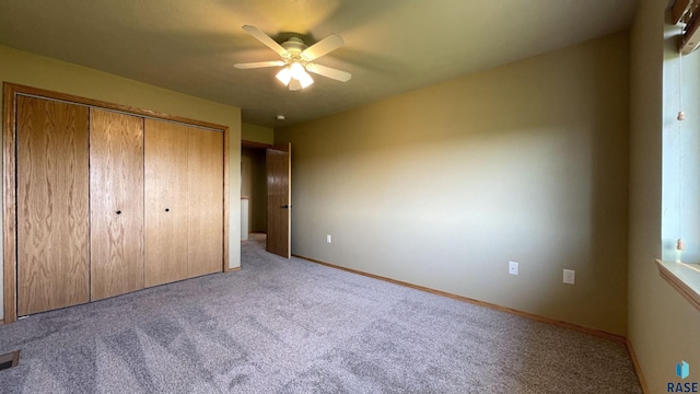 unfurnished bedroom featuring ceiling fan, light carpet, and a closet