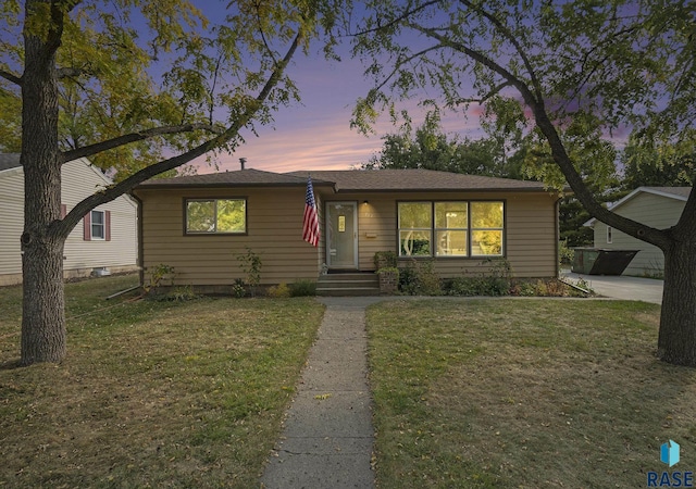 single story home with a lawn