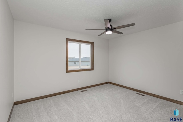 spare room with carpet, a textured ceiling, and ceiling fan