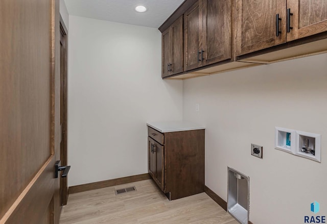 laundry area featuring hookup for a washing machine, light hardwood / wood-style flooring, cabinets, and hookup for an electric dryer