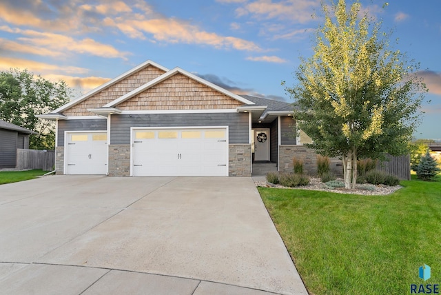 craftsman inspired home with a garage and a yard