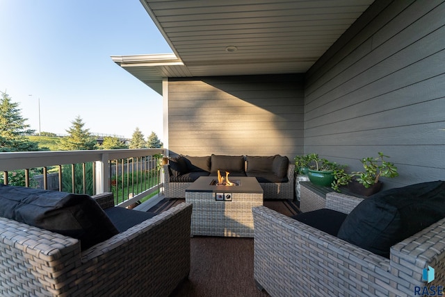 wooden terrace featuring an outdoor living space with a fire pit