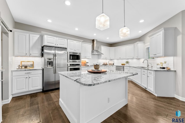 kitchen with sink, a kitchen island, white cabinets, and appliances with stainless steel finishes