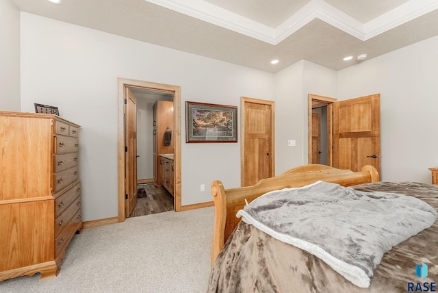 bedroom featuring light carpet, ensuite bathroom, and crown molding