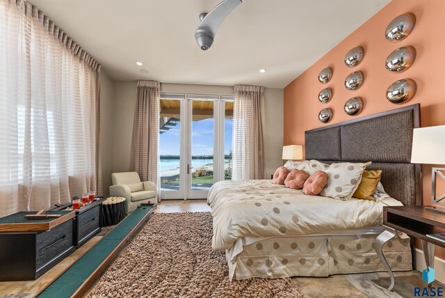 bedroom featuring access to exterior and a water view