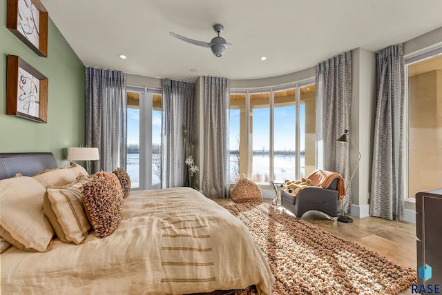 bedroom with a water view and ceiling fan