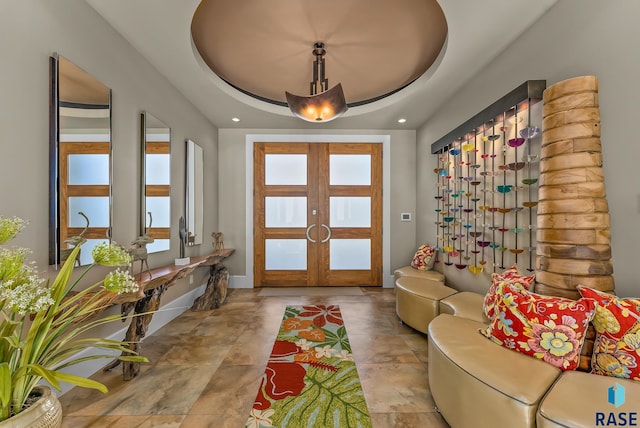 foyer entrance featuring a tray ceiling and french doors