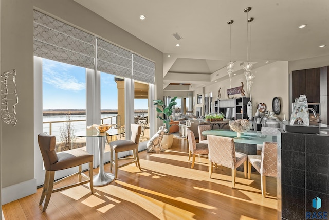 dining space featuring a water view and light hardwood / wood-style floors