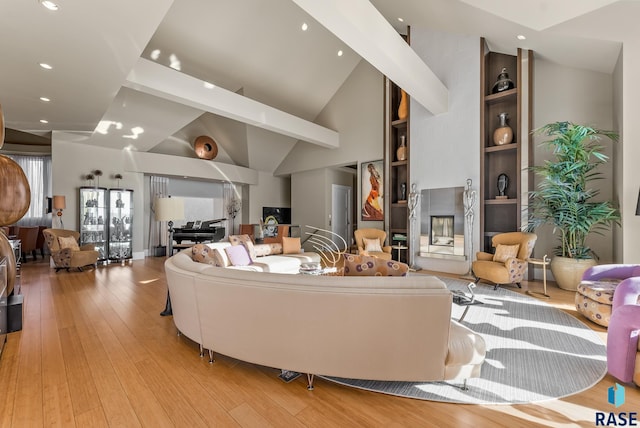 living room featuring a fireplace, high vaulted ceiling, and light hardwood / wood-style flooring