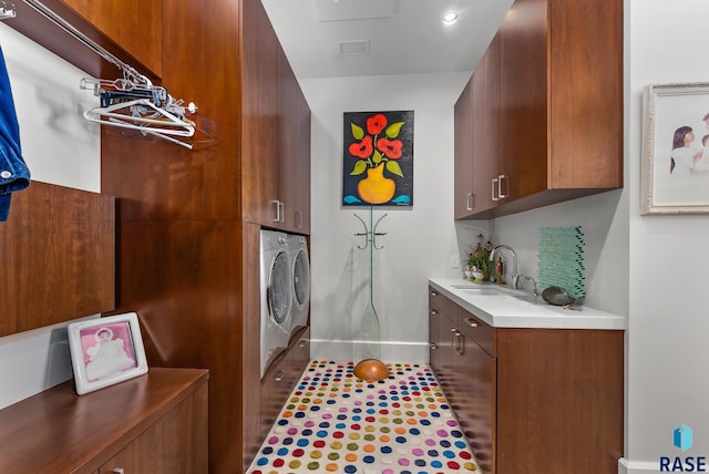 washroom featuring washer and dryer, cabinets, and sink