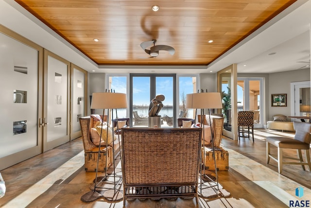 interior space with french doors, a raised ceiling, plenty of natural light, and wooden ceiling