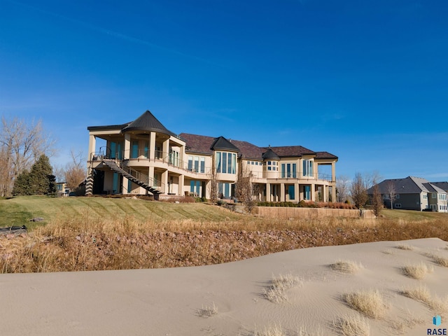 view of front of property with a balcony and a front yard