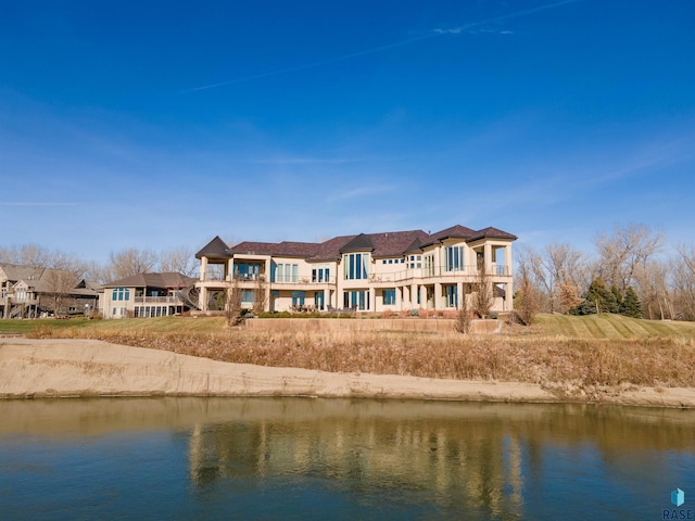 back of property featuring a water view and a balcony