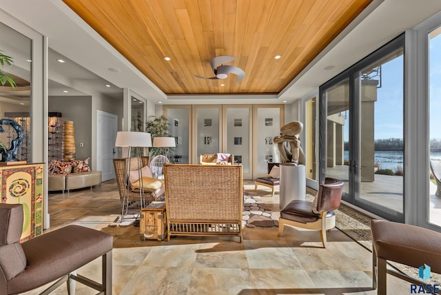 interior space with a water view, wood ceiling, french doors, and a tray ceiling